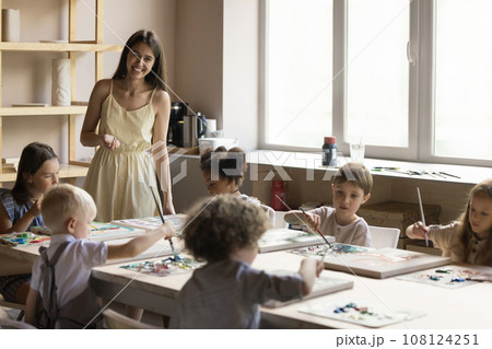 Multiethnic children attend art class led by young artist woman Multiethnic children attend art class led by young artist woman 108124251