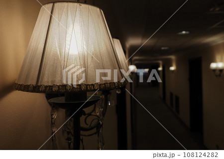 View of lamp on wall in hotel hallway. Dim light in dark hotel corridor. Background with space. for View of lamp on wall in hotel hallway. Dim light in dark hotel corridor. Background with space. for 108124282