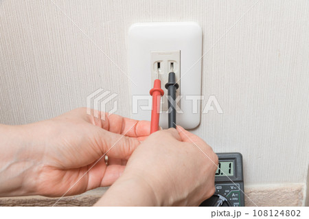 【テスターでコンセントの電圧を計る主婦】 【テスターでコンセントの電圧を計る主婦】 108124802