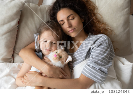 Young mom and little girl sleeping in home bed Young mom and little girl sleeping in home bed 108124848