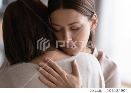 Adult daughter cuddles old mother gives her moral support 108124904