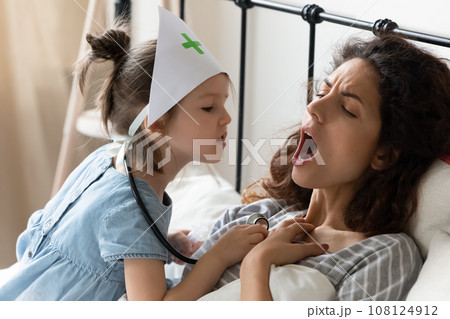 Little girl playing doctor with mom at home Little girl playing doctor with mom at home 108124912
