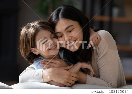 Close up smiling Asian mother and son hugging Close up smiling Asian mother and son hugging 108125054