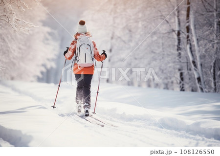 Young woman skiing in a snowy park or forest. Winter activities and sport. AI generated. 108126550