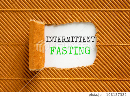 Intermittent fasting symbol. Concept words Intermittent fasting on beautiful white paper. Beautiful brown background. Healthy lifestyle intermittent fasting concept. Copy space. 108127322