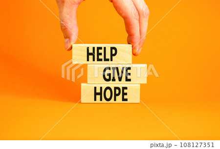 Help give hope symbol. Concept word Help give hope on beautiful wooden block. Businessman hand. Beautiful orange table orange background. Business motivational help give hope concept. Copy space. Help give hope symbol. Concept word Help give hope on beautiful wooden block. Businessman hand. Beautiful orange table orange background. Business motivational help give hope concept. Copy space. 108127351