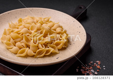 Raw Italian pasta conchiglie from durum wheat with vegetables, salt and spices 108128371