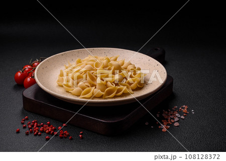 Raw Italian pasta conchiglie from durum wheat with vegetables, salt and spices 108128372