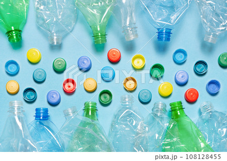 Crushed plastic bottle recycling plastic cap separate bottle lids. Separate waste sorting and recycling PET bottle cap recycling materials. Used PET plastic sorting. Flat lay design 108128455