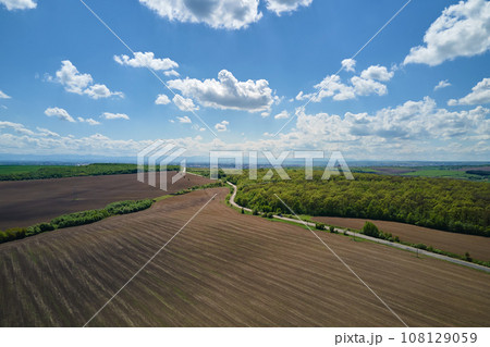 Plowed bare agricultural field with cultivated fertile soil prepared for seeding crops in spring season 108129059