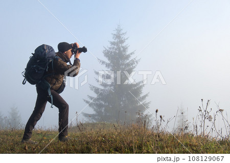Photographer hiker taking picture of nature with digital camera 108129067