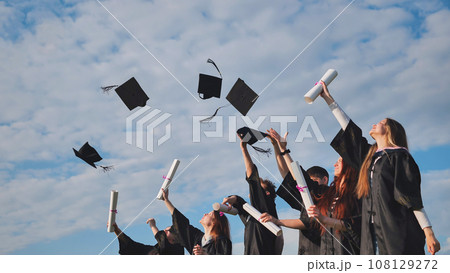 Graduating students hands throwing graduation caps in the air. 108129272