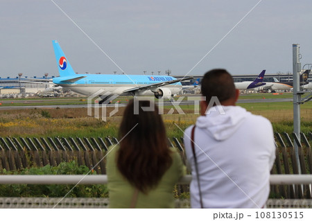 離陸する旅客機を見送る女性 カップル 離陸する旅客機を見送る女性 カップル 108130515
