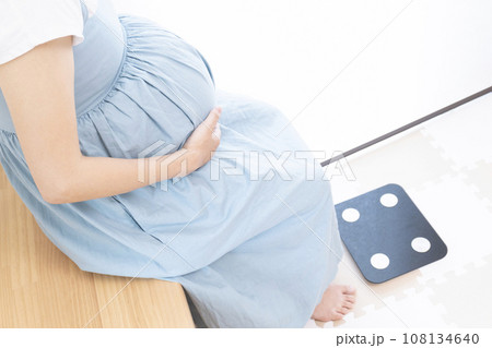 体重計の前に座る妊婦女性 108134640