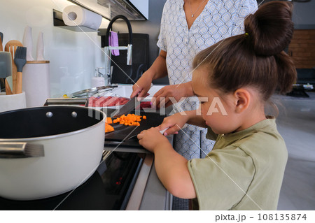 Grandmother and granddaughter are preparing soup. Grandmother and granddaughter are preparing soup. 108135874