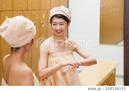 サウナのロッカールームで着替える若い女性 108136155