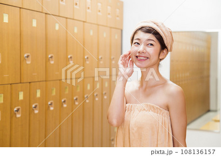 サウナのロッカールームで着替える若い女性 108136157