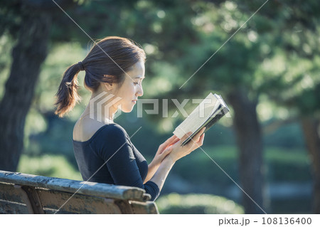 公園のベンチで本を読む女性 公園のベンチで本を読む女性 108136400