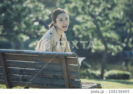 公園のベンチで本を読んで楽しむ女性 108136405