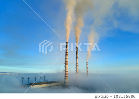 Coal power plant high pipes with black smoke moving upwards polluting atmosphere. Production of electrical energy with fossil fuel concept 108136886