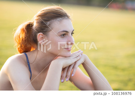 Close up portrait of cheerful smiling young girl with freckles on her face outdoors in sunny summer day. Human expressions and emotions concept. Close up portrait of cheerful smiling young girl with freckles on her face outdoors in sunny summer day. Human expressions and emotions concept. 108136976