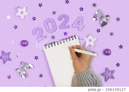 New Year Aims 2024. To Do List. Empty Notebook at the Desk with Holiday Decoration. Top view. Female Hand Creating Plan, Resolution. New Life, Start Up, Beginning Concept. Business idea. Goals, action New Year Aims 2024. To Do List. Empty Notebook at the Desk with Holiday Decoration. Top view. Female Hand Creating Plan, Resolution. New Life, Start Up, Beginning Concept. Business idea. Goals, action 108139127