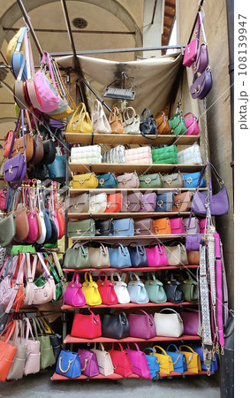Colorful leather purses, handbags, wallets and handbags are displayed by street vendors at the outdoor Lorenzo Market at Florence, Italy. 108139947
