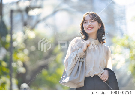 屋外をスーツで歩く若い女性 108140754