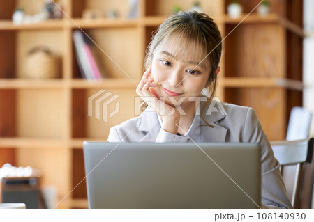 面倒くさそうにパソコンを操作するアジア人女性 面倒くさそうにパソコンを操作するアジア人女性 108140930