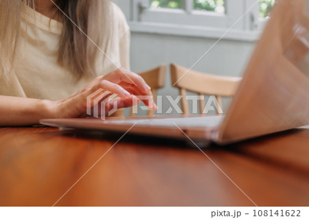 Close up of hands and fingers typing laptop keyboard. Working online in cafe Close up of hands and fingers typing laptop keyboard. Working online in cafe 108141622