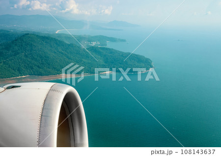Passenger plane flying over blue ocean 108143637