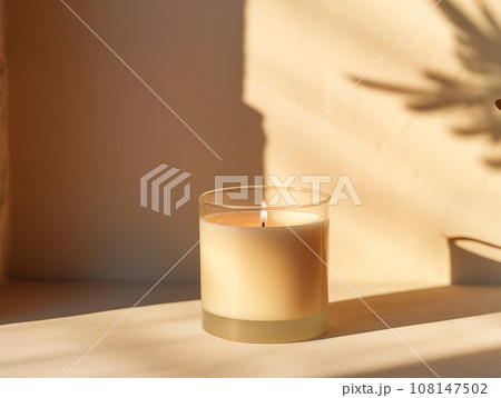 Minimalist burning wax candle in clear glass on natural beige stone background with copy space, styled commercial product mockup Minimalist burning wax candle in clear glass on natural beige stone background with copy space, styled commercial product mockup 108147502