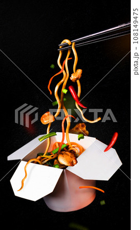 ?hicken lo mein noodles levitation black background Asian noodles in box 108149475