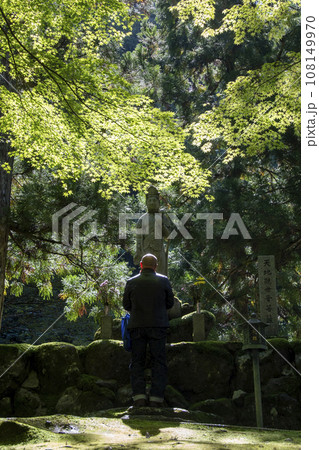 観音菩薩の前で祈る男性 108149970