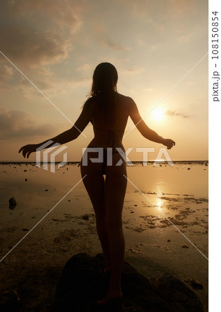 silhouette of girl on the beach at sunset silhouette of girl on the beach at sunset 108150854