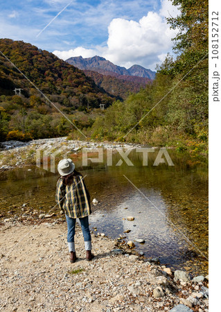 秋の湯桧曽川から谷川岳を眺める女性 秋の湯桧曽川から谷川岳を眺める女性 108152712