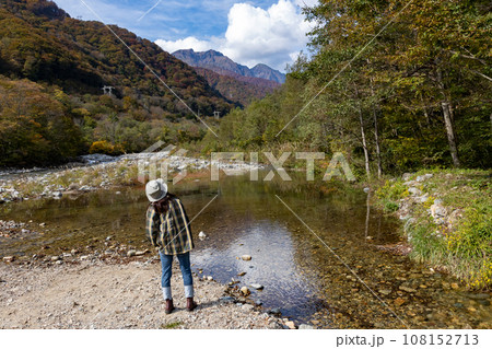 秋の湯桧曽川から谷川岳を眺める女性 秋の湯桧曽川から谷川岳を眺める女性 108152713