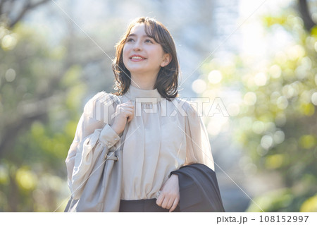 屋外をスーツで歩く若い女性 108152997