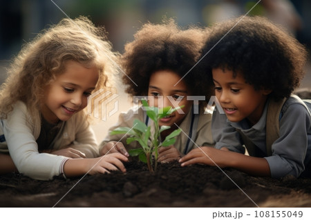 Beautiful little multi-ethnic children bend over a tiny green sprout in the garden. Adorable enfants with different skin colors plant a plant in the ground together. Diversity and free communication. 108155049