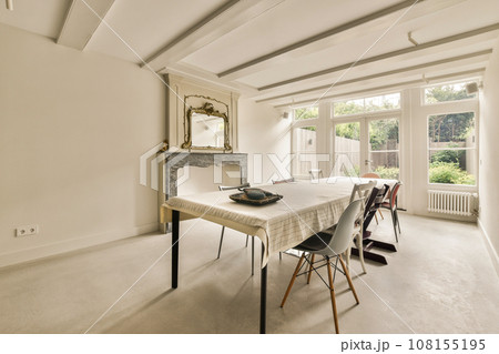 a dining room with a table, chairs and a fire place in the middle of the room that is empty 108155195