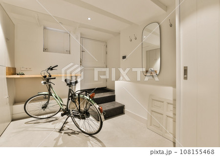 a room with a bike parked next to the door and a mirror hanging on the wall above it that's attached storage space a room with a bike parked next to the door and a mirror hanging on the wall above it that's attached storage space 108155468
