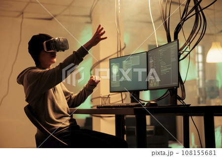 Hacker coding malware in vr glasses, hacking database in metaverse, stealing privacy information, data breach. Cyberattack in virtual reality, internet criminal breaking into online server Hacker coding malware in vr glasses, hacking database in metaverse, stealing privacy information, data breach. Cyberattack in virtual reality, internet criminal breaking into online server 108155681