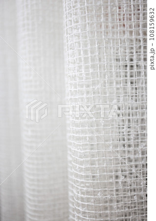 White curtains in the form of a mesh. Abstract background. Selective focus. White curtains in the form of a mesh. Abstract background. Selective focus. 108159632