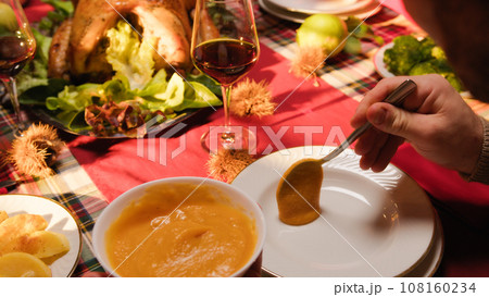 Hand serving sauce for roasted turkey on Thanksgiving  108160234