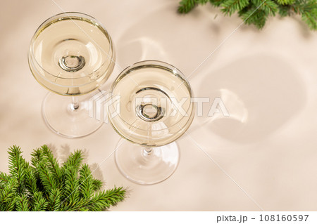 Two champagne glasses on a beige 108160597