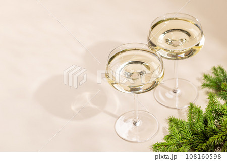 Two champagne glasses on a beige 108160598