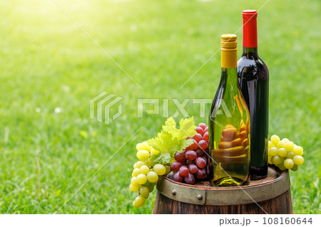 Wine bottles and grape on barrel 108160644