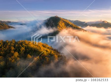 Aerial view of mountain peak in low clouds at sunrise in autumn 108162533