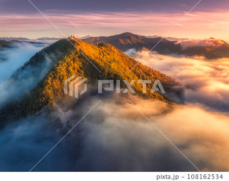 Aerial view of mountain peak in low clouds at sunrise in autumn 108162534