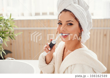 happy beautiful young woman in cozy bathroom with with toothbrush in the hand. Beauty and healt care concept. 108162589